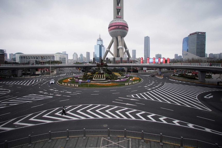 You view a wide shot of a large Shanghai intersection with a globe-like tower pictured behind it.
