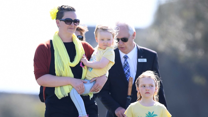 Briony Lyle and daughters Lusi and Jemma at a public memorial service for golfer Jarrod Lyle.
