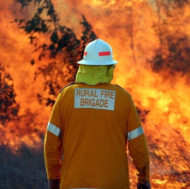 An unidentified member of Queensland's rural fire brigade faces a large blaze