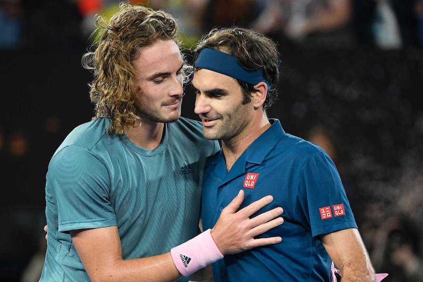 Stefanos Tsitsipas hugs Roger Federer at the net.