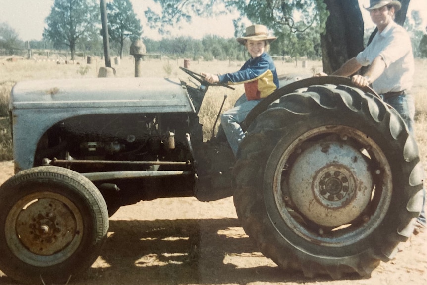 Jodie sits on a tractor as a child