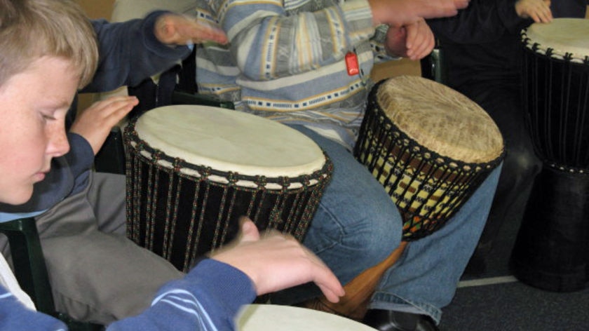 Primary school students play african drums