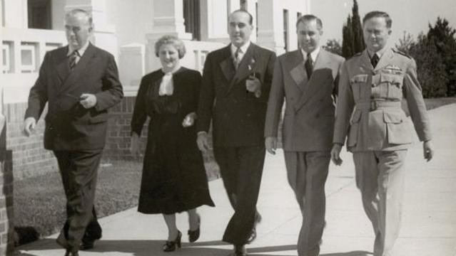 Robert Menzies, Dame Enid Lyons and others walk outside Parliament House
