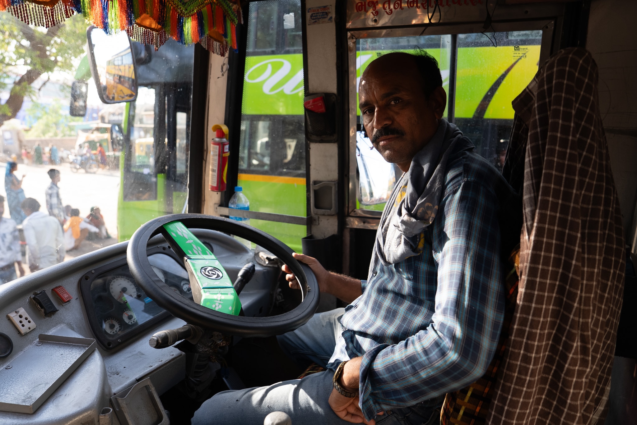 An Indian man sits in a bus 