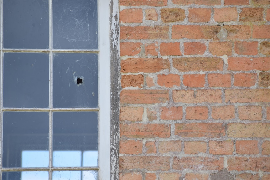 A whole in a glass window. The building is red brick.