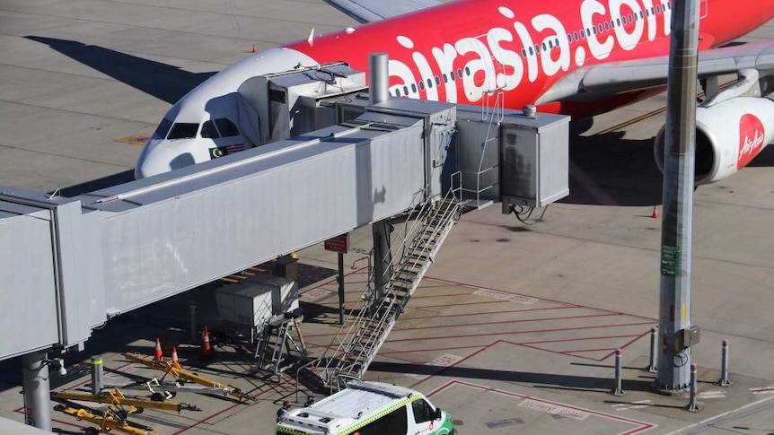Sebuah ambulans bersiaga di dekat pesawat AirAsia ketiba ia tiba di Bandara Perth setelah ada kasus kematian bayi.