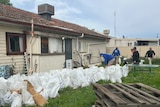 Sandbags piled up outside an old weatherboard home