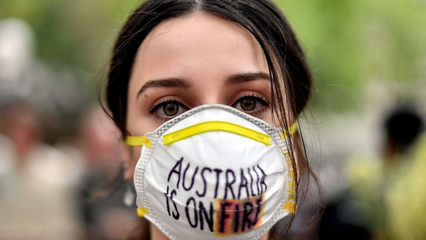 A demonstrator with a mask attends a climate protest rally in Sydney on December 11, 2019.
