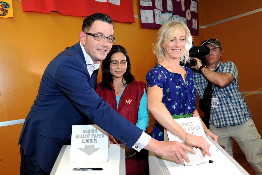Daniel Andrews and his wife Catherine place voting papers in a ballot box.