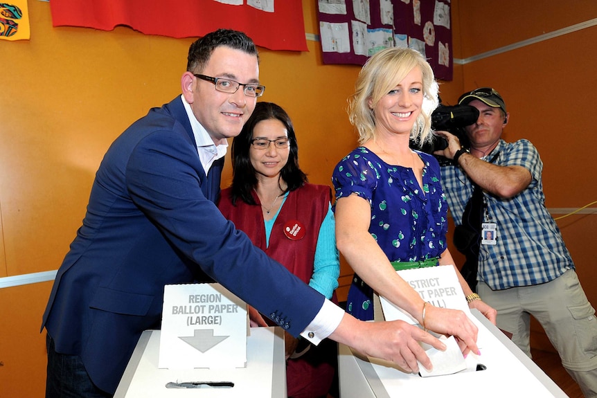 Daniel Andrews and his wife Catherine place voting papers in a ballot box.