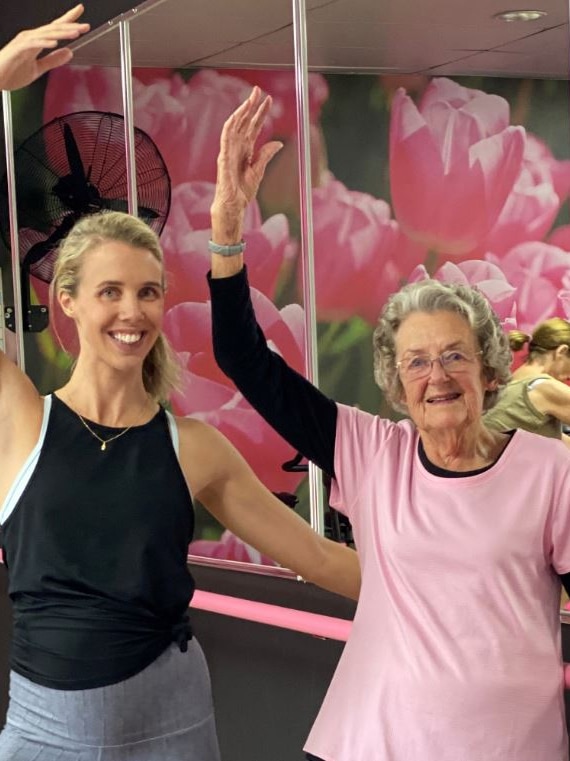 A younger woman and an older woman doing a ballet pose