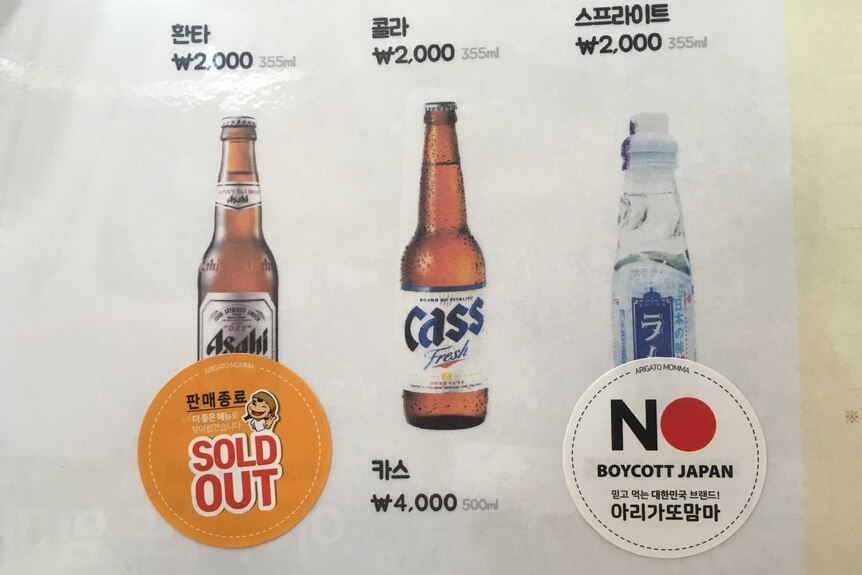 Menu showing pictures of three beverages, Japanese drink has "Boycott Japan" sticker placed on it.