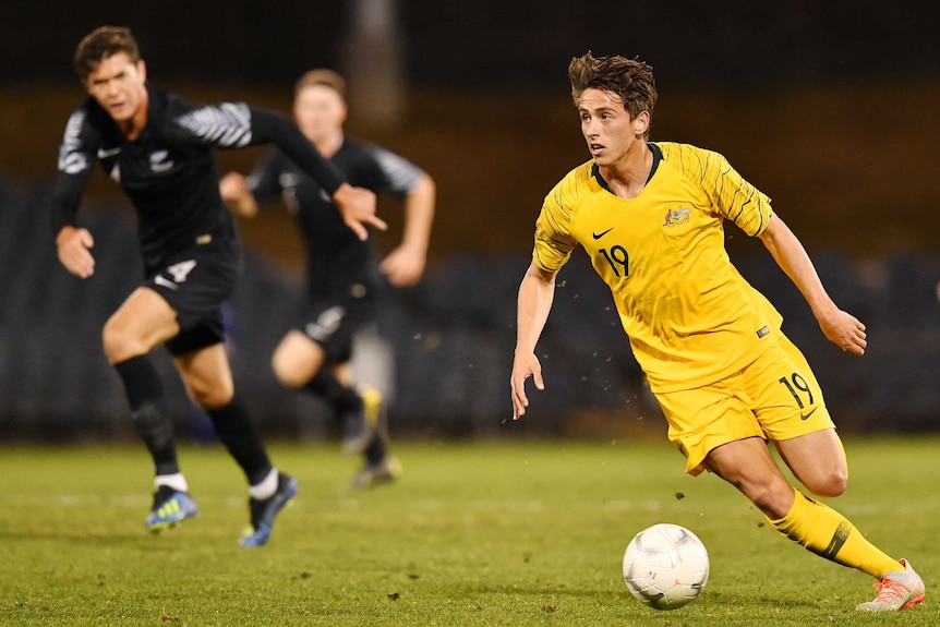 An Australian Olyroos player kicks the ball as he plays against New Zealand.