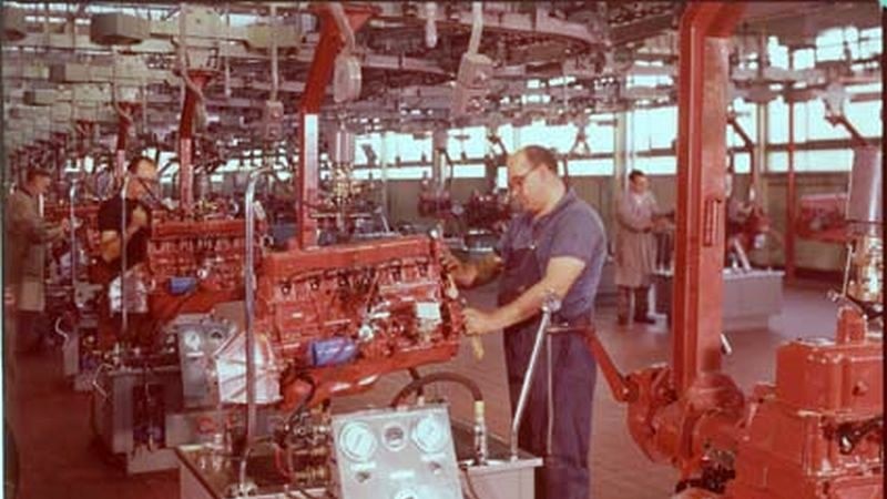 A Holden worker works on a car engine.