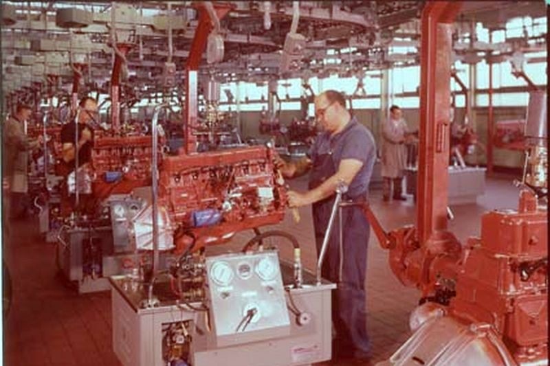 A Holden worker works on a car engine.