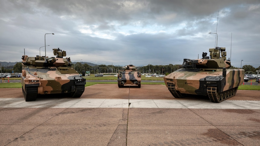 Three tanks next to each other on an open field