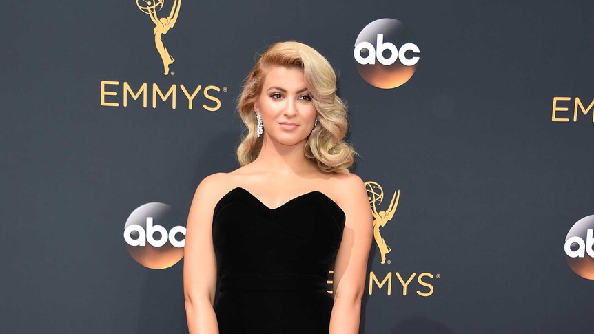 Singer Tori Kelly at the 2016 Emmy Awards in a long black dress on the red carpet