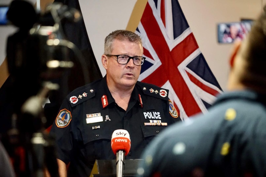 NT Police Commissioner Jamie Chalker stands and looks concerned at a press conference.