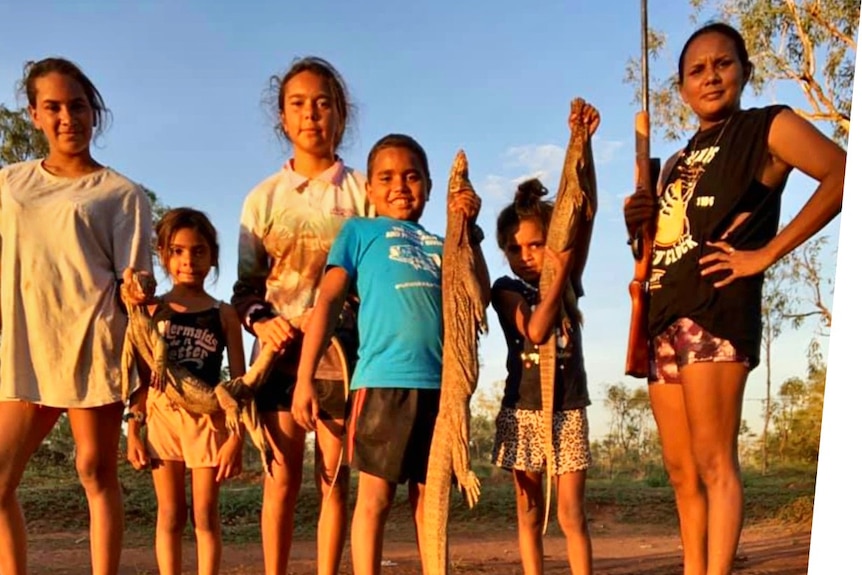 A group of Indigenous children post for the camera after hunting for traditional food.