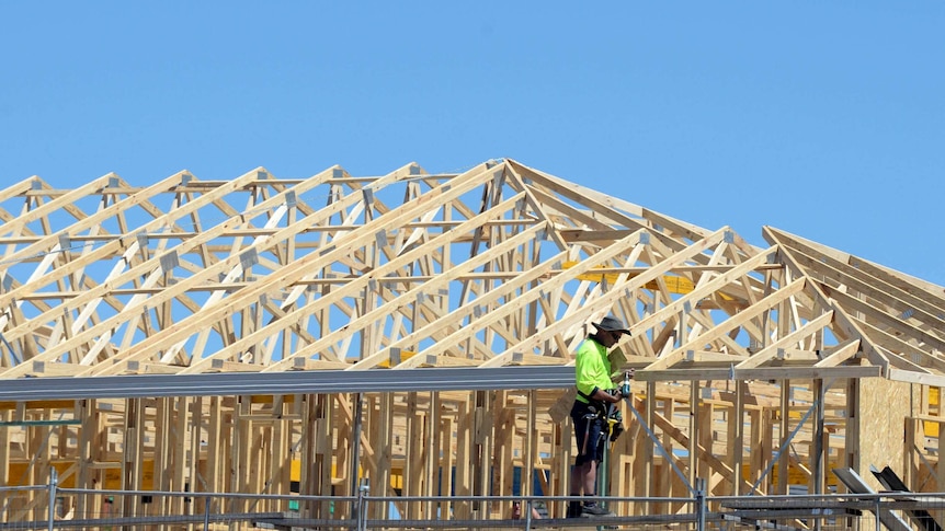 A man works on a house under construction.