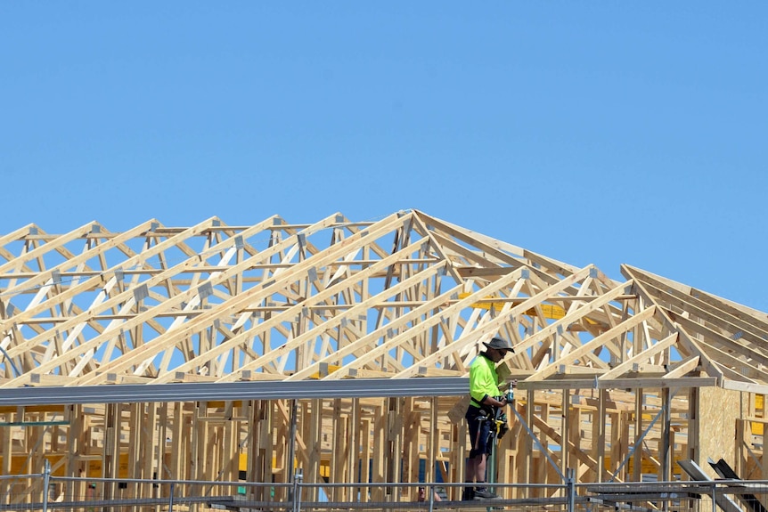 A man works on a house under construction.