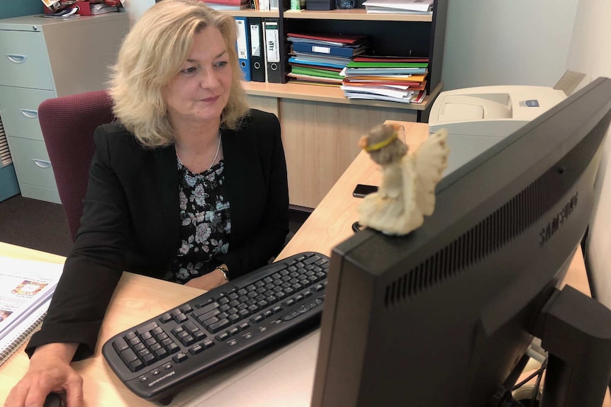 Clinical psychologist Karen Aspinall, and manager of Laurel Place, sits at a desk working on a computer.