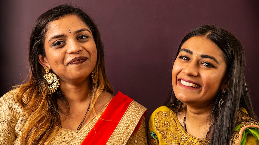 Friends Hemangini Patel and Meera Patel wear traditional Indian clothing, jewellery and bindis.