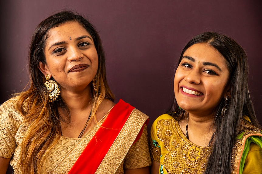 Friends Hemangini Patel and Meera Patel wear traditional Indian clothing, jewellery and bindis.