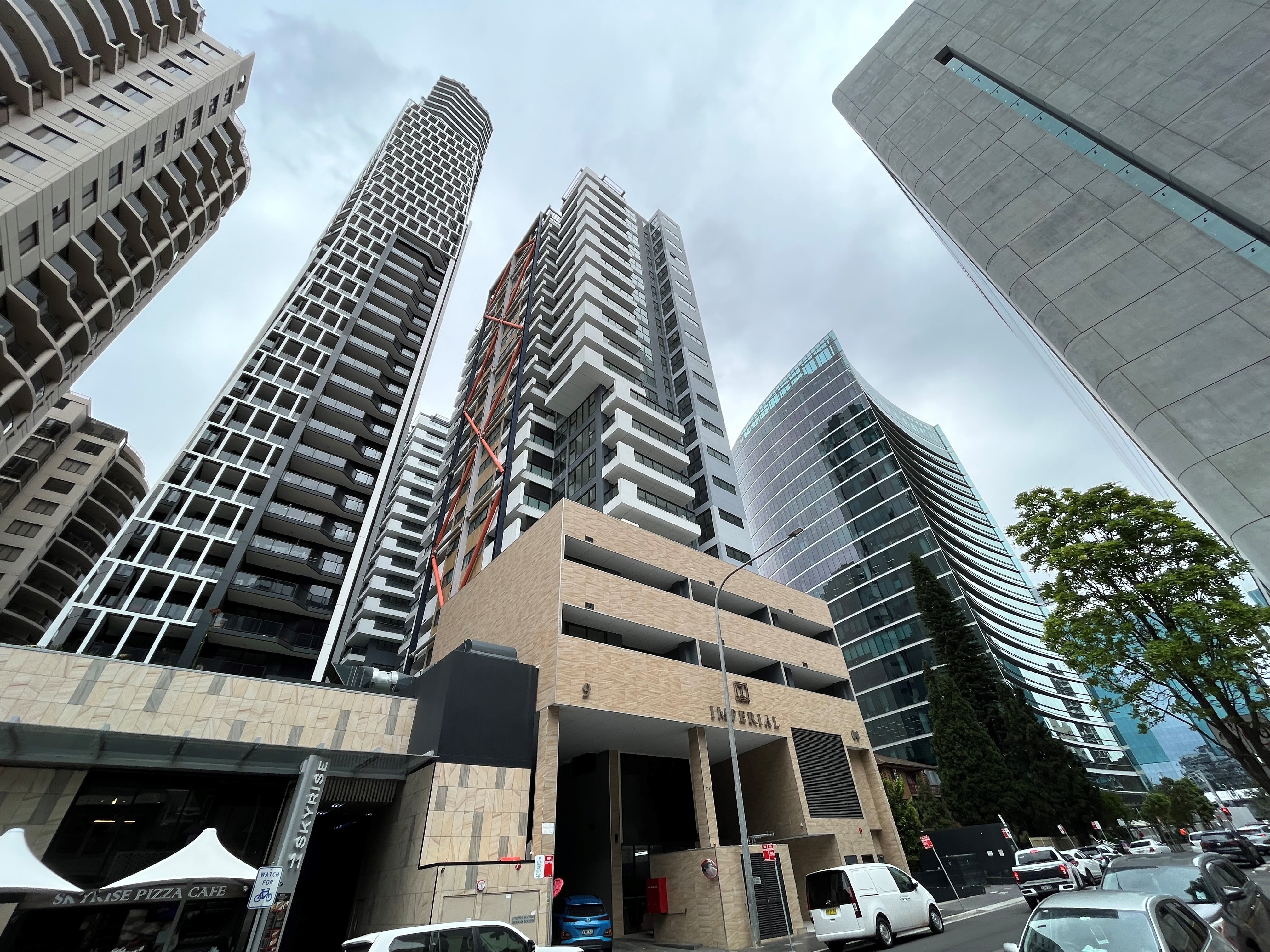 Two 22-storey sandy coloured apartment high rises in Parramatta street in front