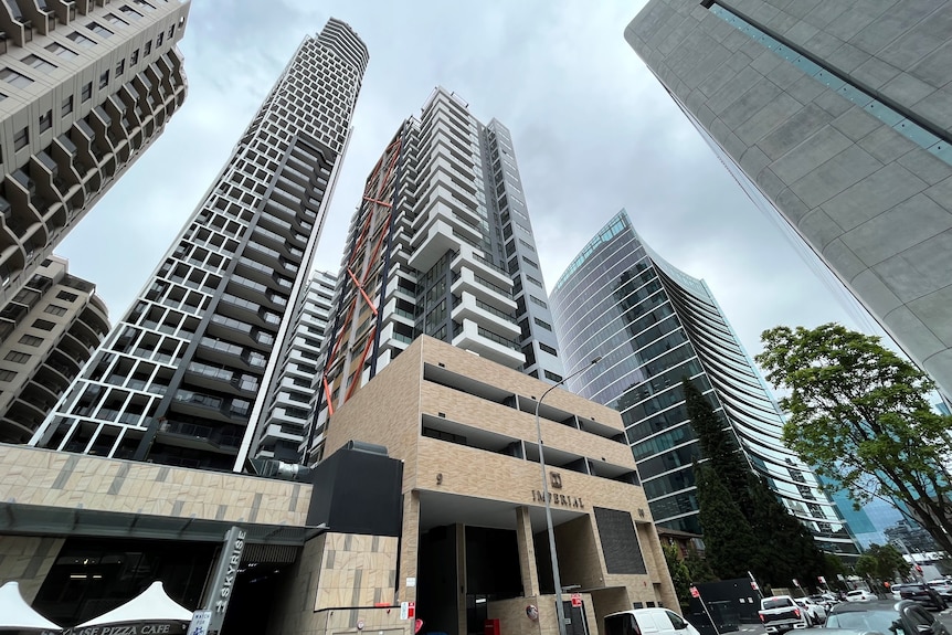 Two 22-storey sandy coloured apartment high rises in Parramatta street in front