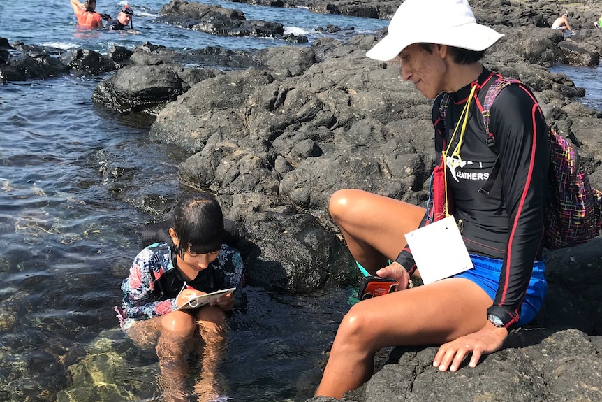 Danielle Florens and her daughter Lani Hill using the coral health chart.