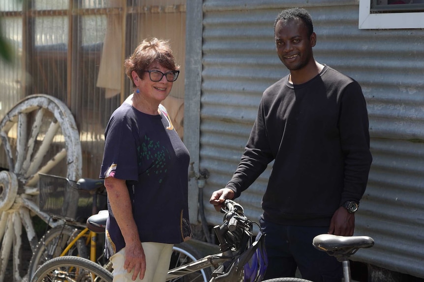 Marie Sellstrom and Mizamu Mahari stand with a bike.