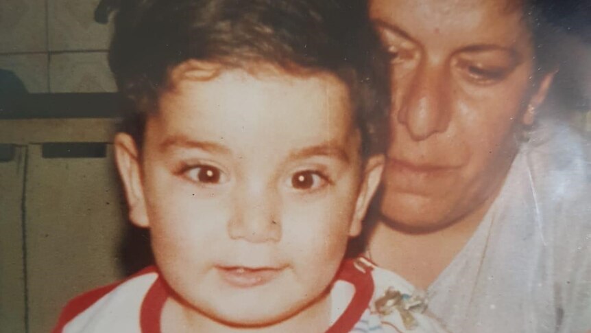 Fadi Chalouhy as a toddler sitting on his mother's lap.
