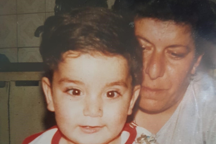Fadi Chalouhy as a toddler sitting on his mother's lap.