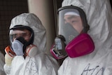 Workers in protective suits wait outside of J-Village following nuclear clean up in 2011.