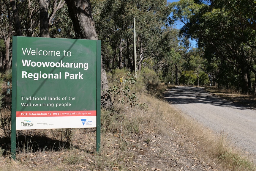 A sign that says Woowookarung Regional Park in front of bush.