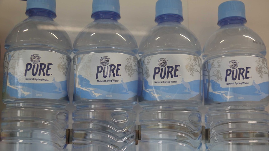 Four bottles of water in a vending machine.