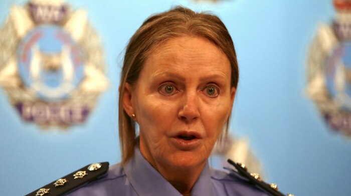 Inspector Louise Ball standing in front of a blue WA Police backdrop