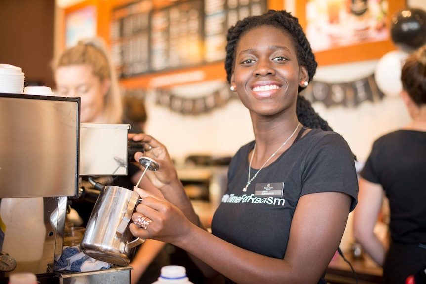 South Sudanese migrant Josie Ajak works behind the counter of a Cairns cafe.