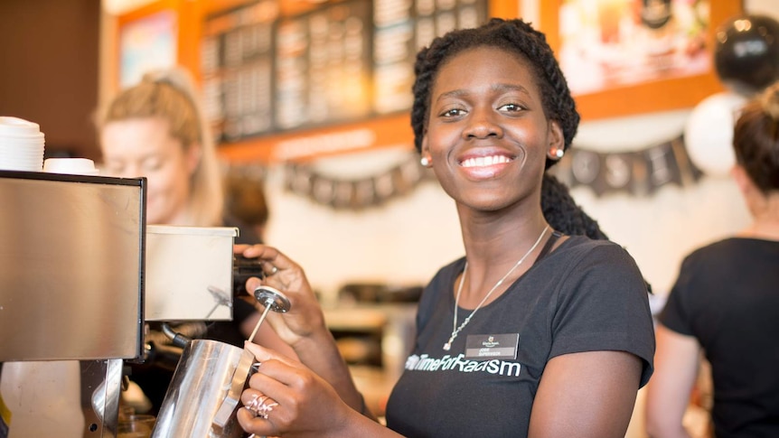 South Sudanese migrant Josie Ajak works behind the counter of a Cairns cafe.