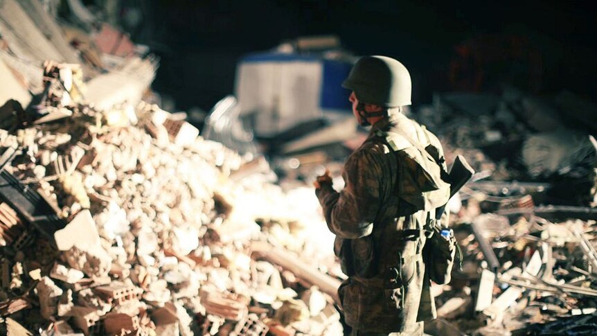 Soldier looks at Turkish quake rubble