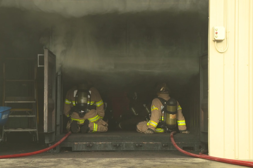 Firefighters site inside a shed with smoke coming from it