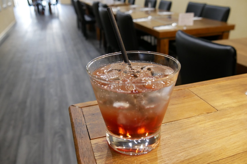 red drink in glass with straw