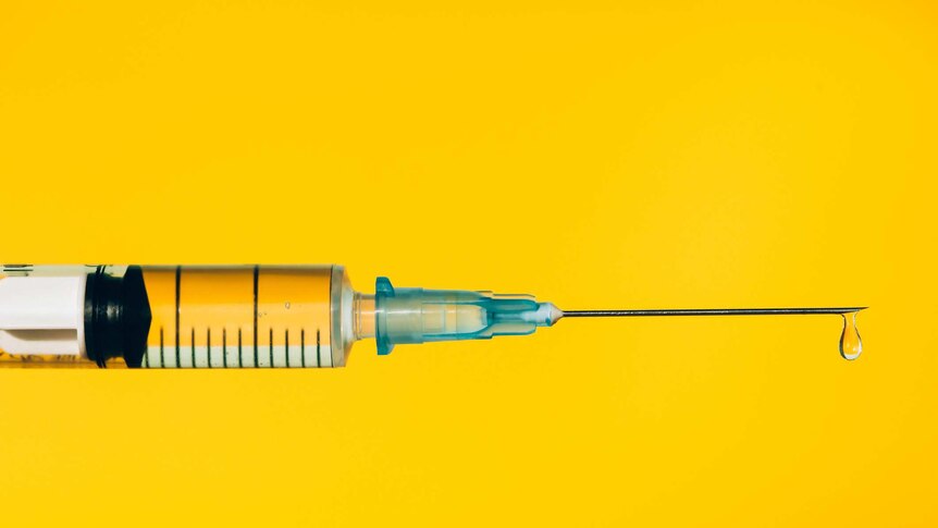 A syringe against a yellow background