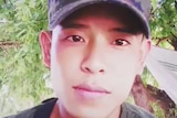 A young man wearing a Thai military cap.