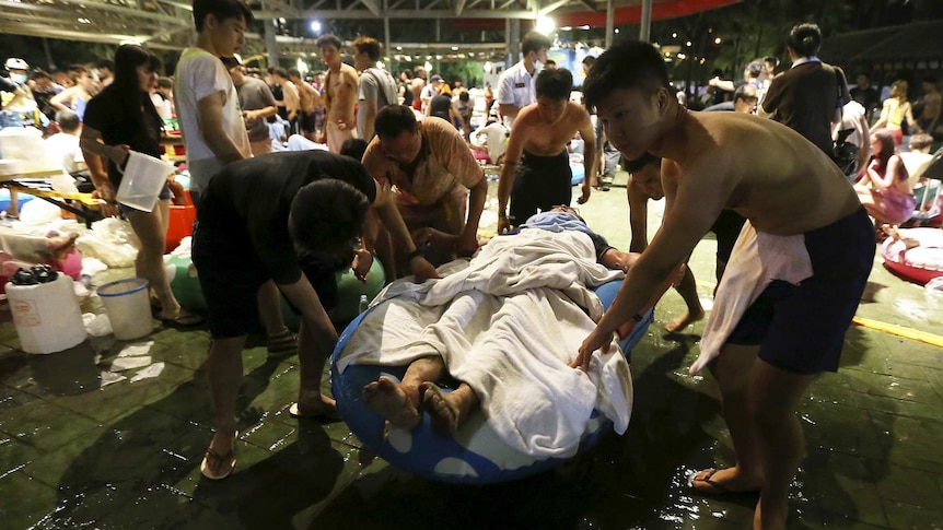 People carry an injured victim from the water park explosion.