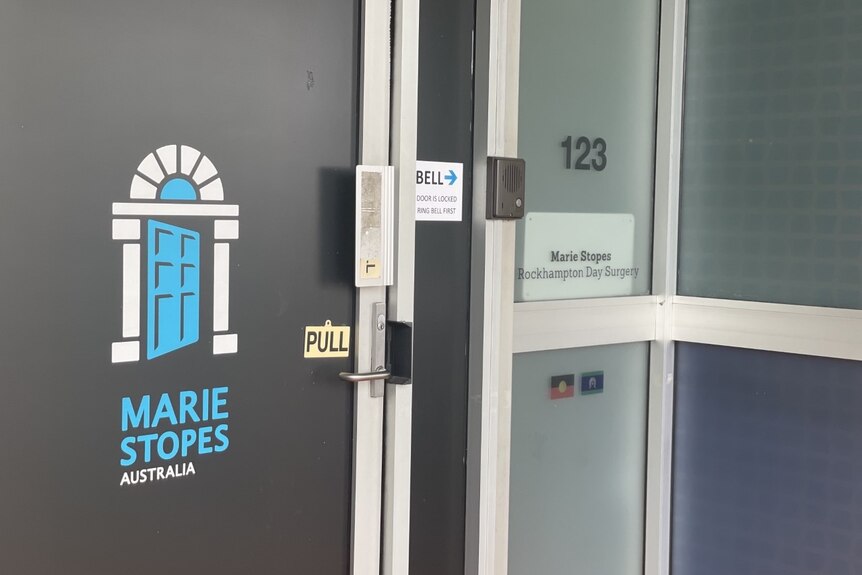 A grey door with a Marie Stopes sign. 
