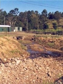 A brown landscape with a small creek.