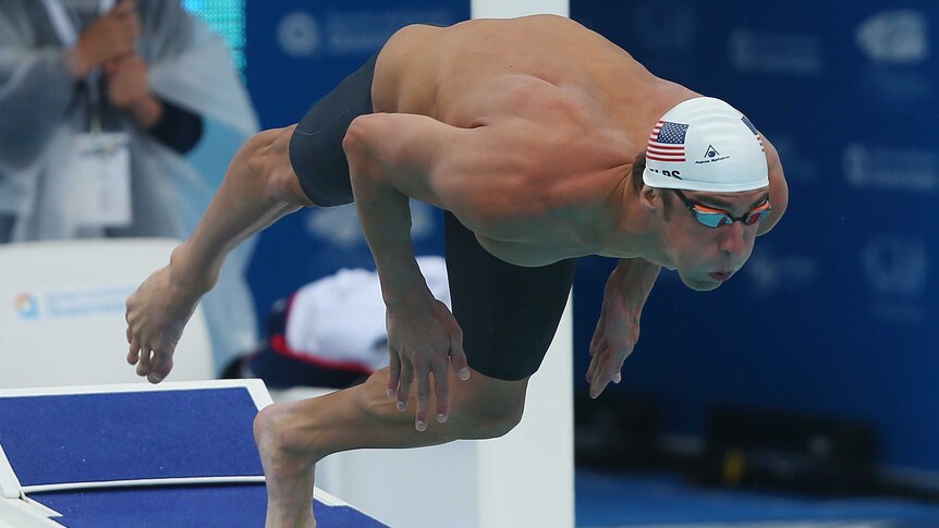 Michael Phelps competes in the 100m freestyle heats