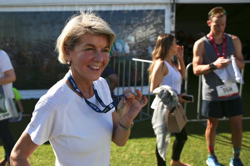 Woman poses with a running medal
